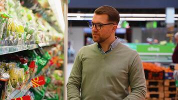 Man browsing fresh salad options in grocery store aisle video