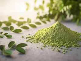 Moringa powder on a surface with fresh leaves surrounding it photo