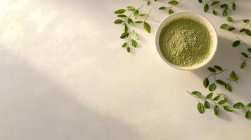 Moringa powder displayed in a bowl with fresh leaves nearby photo