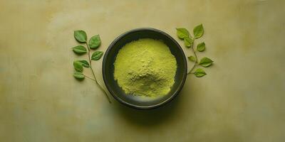 Moringa powder in a bowl surrounded by fresh leaves photo