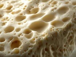 Soft cheese with creamy texture and airy bubbles during close-up photo