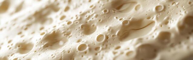 Soft cheese with smooth texture and varied surface features close-up photo