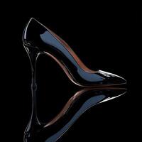 Elegant black high heel shoe against a dark background photo
