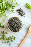 Natural shilajit powder on a kitchen countertop with herbs photo