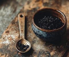 Shilajit in a rustic bowl with metal spoon on wooden surface photo
