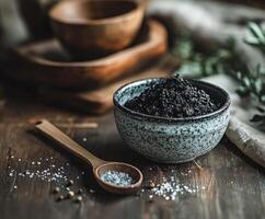 Shilajit powder displayed in a bowl with wooden utensils nearby photo