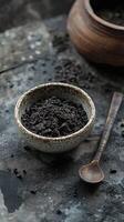 Shilajit resin in a small bowl with a wooden spoon photo