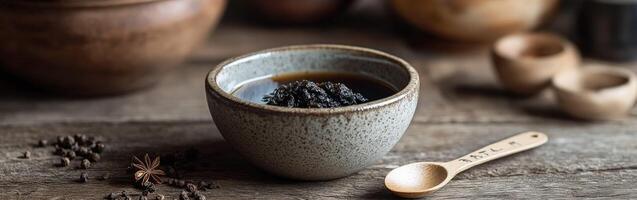 Shilajit resin in a ceramic bowl on a rustic wooden table photo