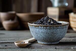 Shilajit resin in a rustic bowl with wooden spoon on table photo