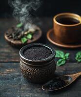 Shilajit resin in decorative container with herbal tea and leaves photo