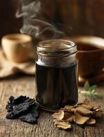 Natural shilajit resin in a jar with herbal ingredients on wood photo