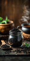 Natural shilajit resin in a glass jar with herbal tea background photo