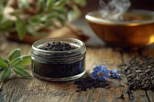 Shilajit resin in glass container with herbs and tea in background photo