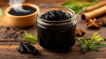 Shilajit resin in a glass jar with herbs and spices photo