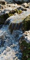 Flowing river water cascades over moss-covered rocks photo