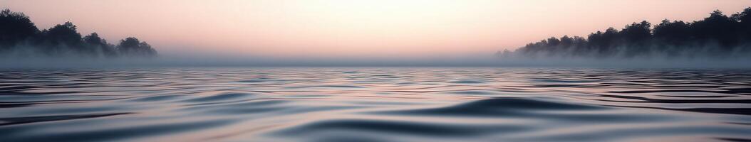 Calm river water at dawn surrounded by mist and trees photo