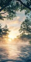 Calm river water reflecting the sunrise through misty trees photo
