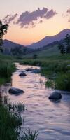 Tranquil river at sunset with mountains and boulders in view photo