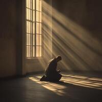 hombre arrodillado en un iluminado por el sol habitación con dramático oscuridad a oscuridad foto