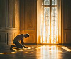 Man kneeling in sunlight with soft shadows in elegant room photo