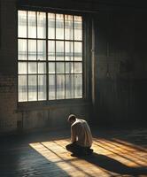 Man in contemplative pose gazing at sunlight through window photo