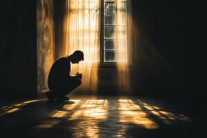 Silhouette of a person in deep thought by a sunlit window photo