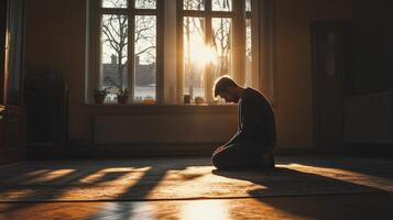Individual meditating in a sunlit room at sunset photo