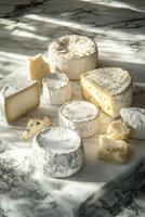 Assortment of artisanal cheeses on marble countertop in natural light photo