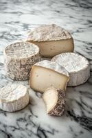 Artisan cheese selection displayed on a marble surface photo
