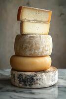 Cheese varieties stacked artfully on a marble surface photo