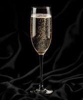 Sparkling drink in elegant flute against black backdrop photo