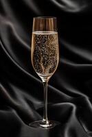 Sparkling drink in elegant glass on black silk fabric photo