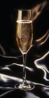 Elegant champagne flute filled with sparkling drink on dark fabric photo