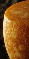 Parmesan cheese wheel on rustic wooden surface showcasing texture and color in a well-lit kitchen setting photo