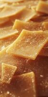 Parmesan cheese slices arranged on a wooden surface showcasing texture and color during a culinary preparation photo