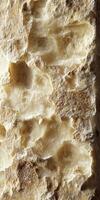 Variety of textures and colors in a block of parmesan cheese displayed on a wooden background photo