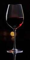 Elegant glass of red wine reflecting soft light in a dark setting showcasing the beauty of a fine vintage photo