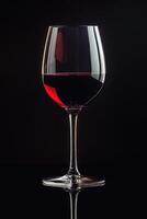 Elegant red wine glass against a dark background showcasing rich color and clarity photo