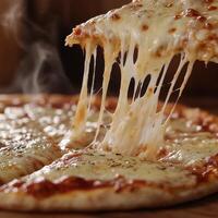 Melted cheese pizza being pulled apart with steam rising in cozy pizzeria during evening hours photo
