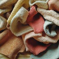 Colorful assortment of soft fabrics strewn together on a warm surface at home photo