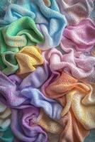 Colorful woven textiles arranged neatly on a surface displaying various pastel shades and patterns in soft lighting photo