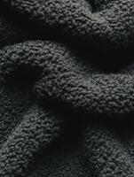 Dark boucle fabric featuring a textured weave that adds depth and character to textiles and fashion items photo