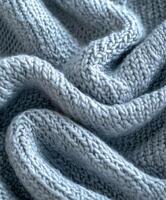 A soft blue boucle fabric gently cascades, beautifully illuminated by the natural light streaming indoors photo
