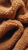 Close-up of soft boucle fabric in warm brown tones showcasing intricate textures and inviting warmth perfect for cozy designs photo