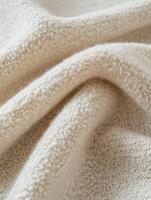 Elegant boucle fabric in soft cream tone draping gently across a surface photo