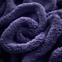 Soft and plush boucle fabric in deep purple color showcases intricate textures and luxurious feel ideal for home decor photo