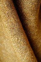 Boucle fabric displayed in warm golden tones, highlighting its texture and weaving pattern for textile enthusiasts photo