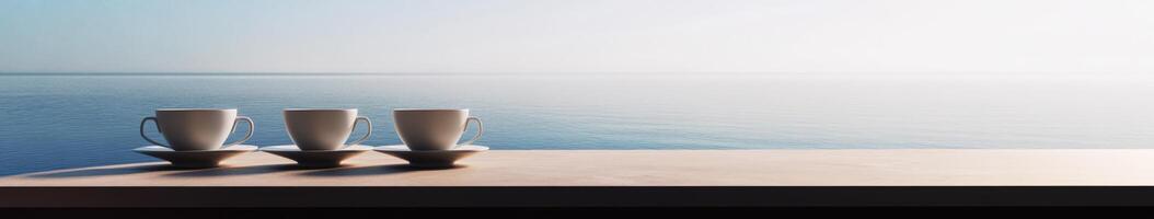 Three coffee cups sitting on a table near the ocean photo