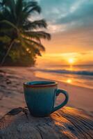 Beautiful sunset over a tranquil beach with a steaming mug resting on driftwood photo