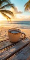 Warm cup of coffee rests on a rustic table by the beach at sunrise creating a serene morning setting photo